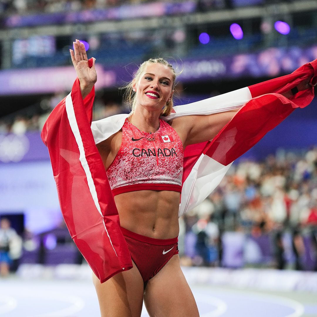 Alysha Newman envuelta en la bandera de Canadá, celebrando su medalla de bronce en los Juegos Olímpicos de París 2024.